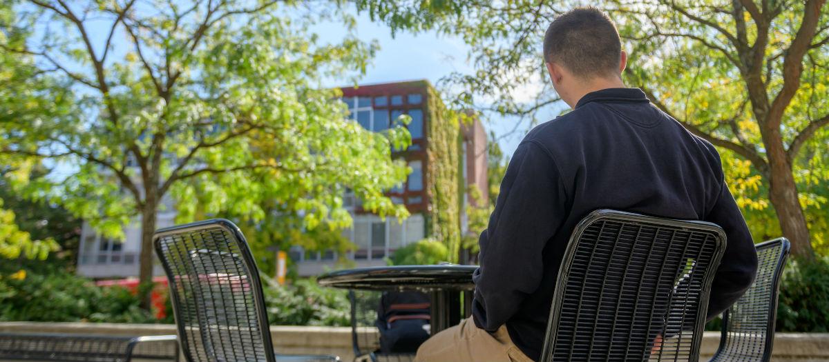 student sitting outside on U of I campus